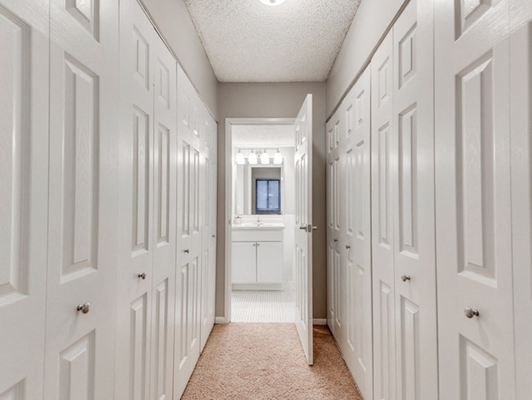 In between two rows of closets with a bathroom at the end of the hall